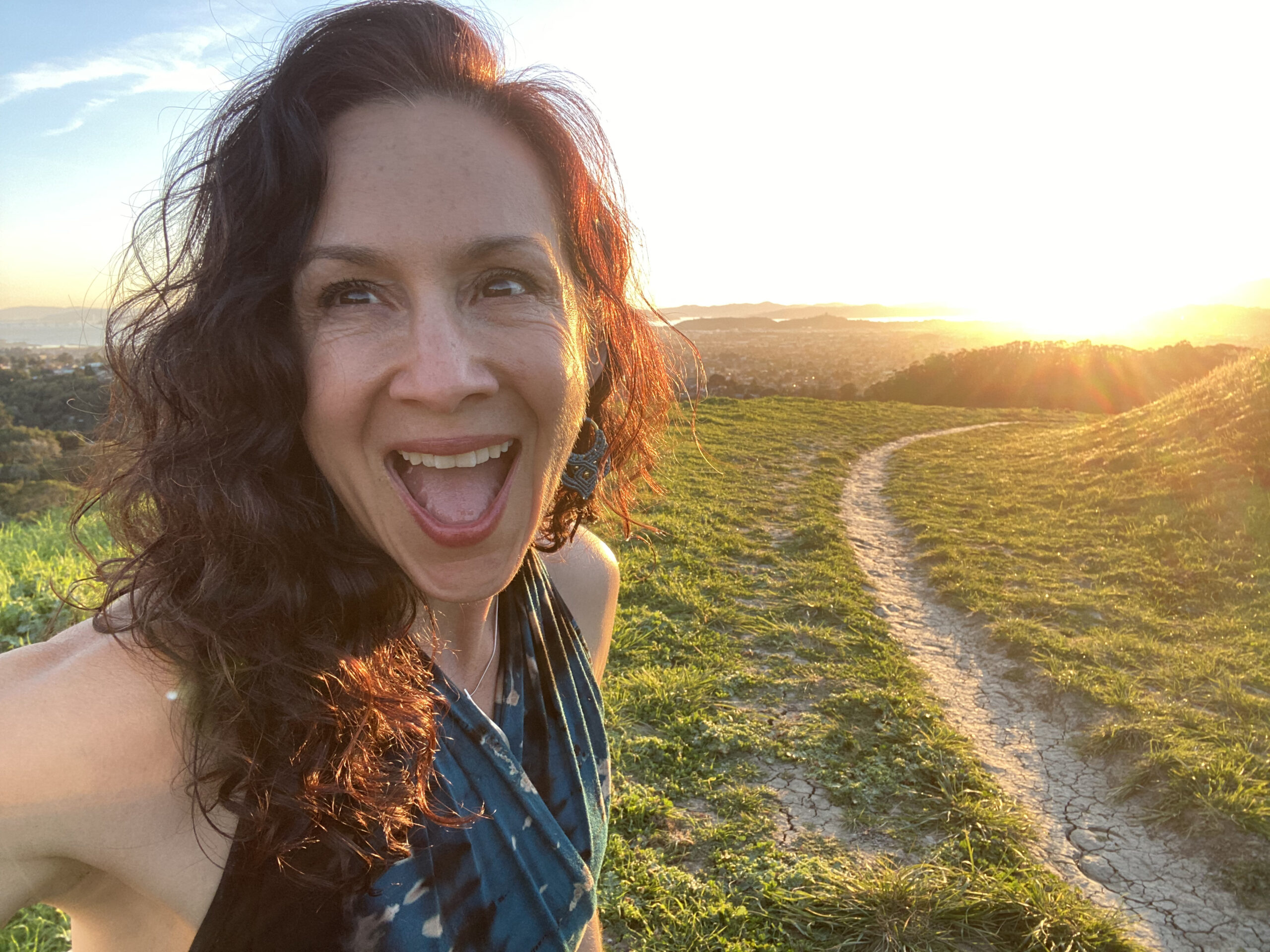 Lun in the field at sunset, smiling in a blue dress